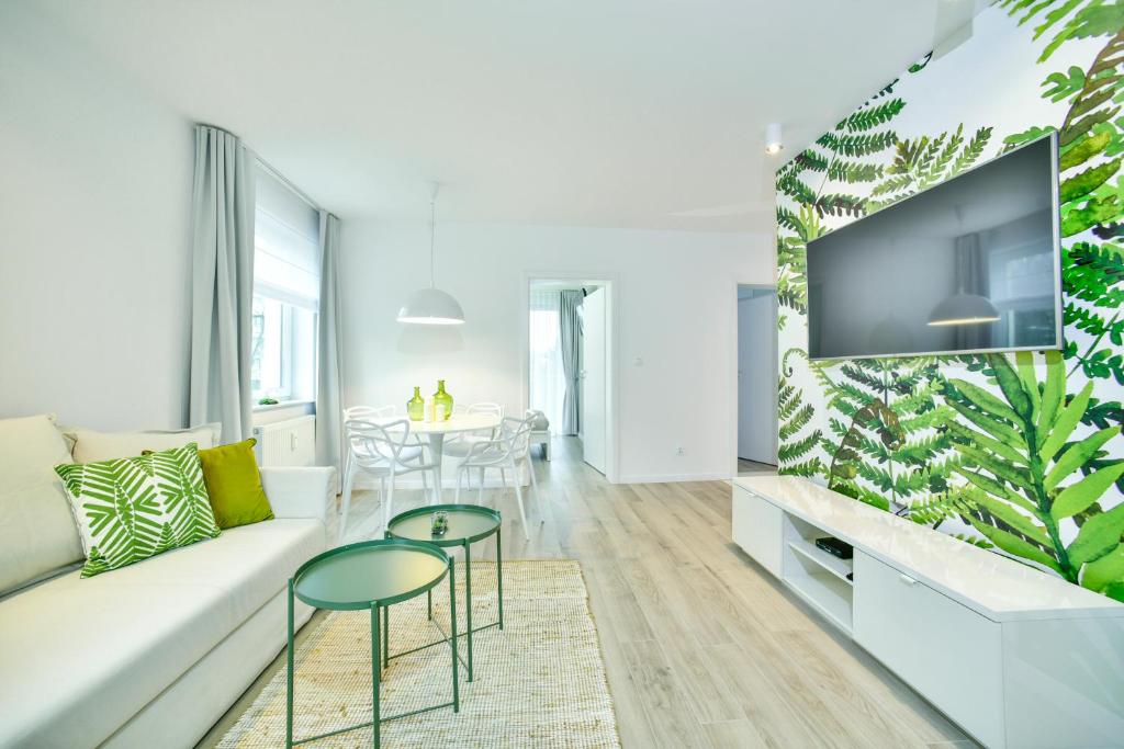 sala de estar con sofá blanco y TV en CHILLIapartamenty - Bliżej Morza - GREEN en Kołobrzeg
