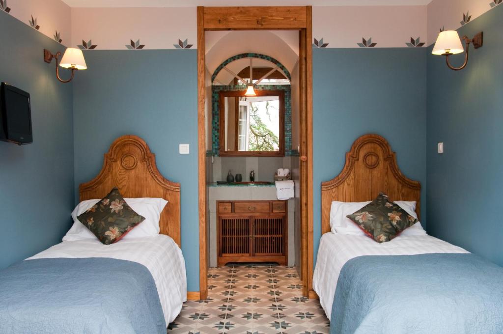 A bed or beds in a room at Les Jardins de l'Hacienda