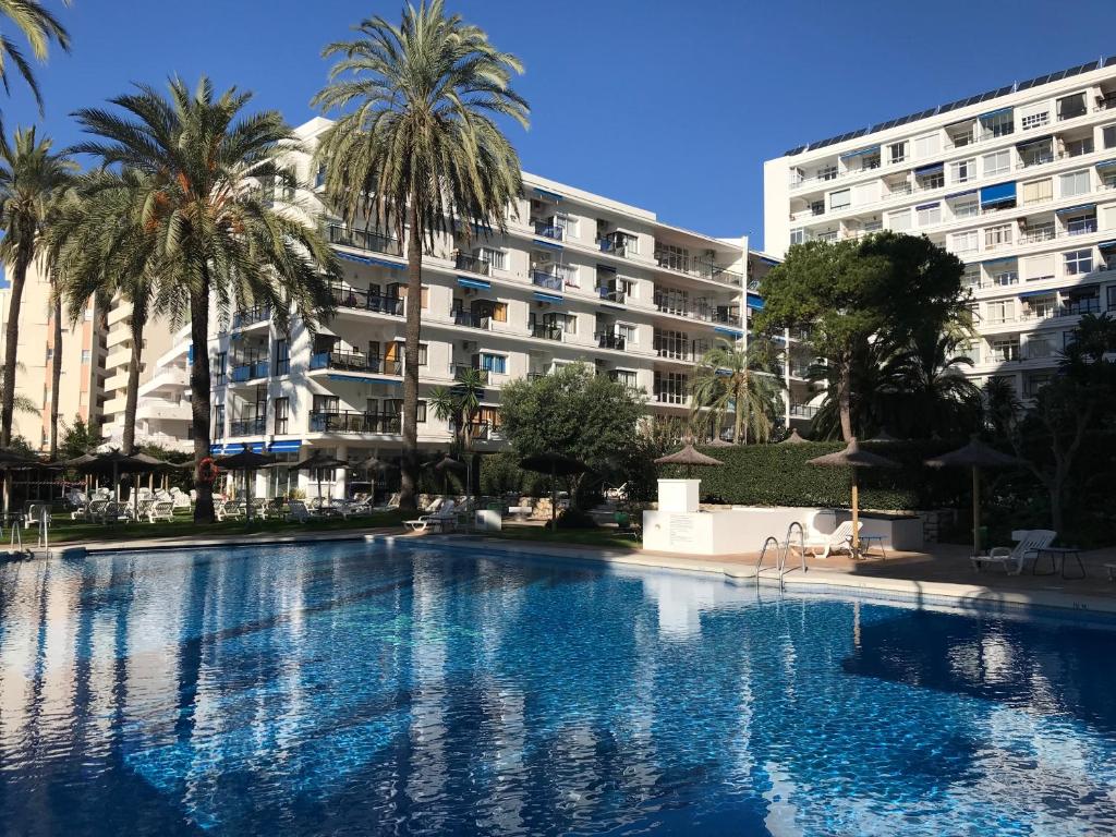 a large swimming pool with a large building behind it at Skol Apartments Marbella in Marbella