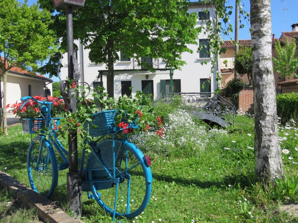 Una bicicleta azul estacionada en el césped con flores en Agriturismo Ca' Marcello, en Mira