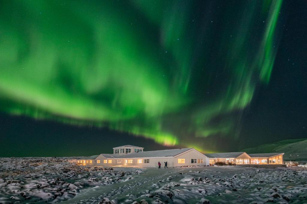 a building under the aurora in the sky at Northern Light Inn in Grindavík