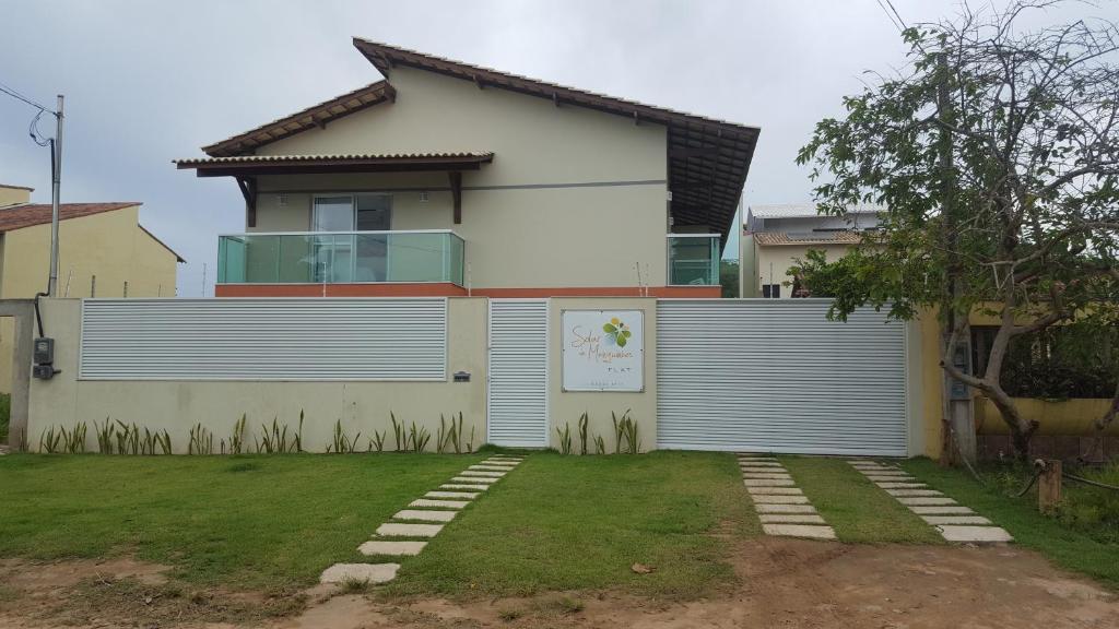 uma casa branca com uma cerca à frente. em Solar de Manguinhos Flat em Manguinhos