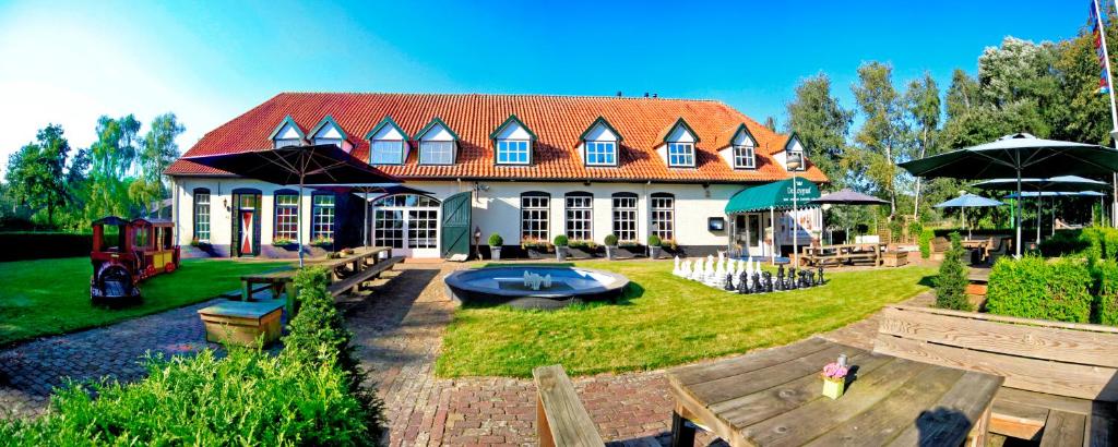 a large house with a yard with a playground at OKE HOTEL De Leygraaf Heeswijk Dinther in Heeswijk-Dinther