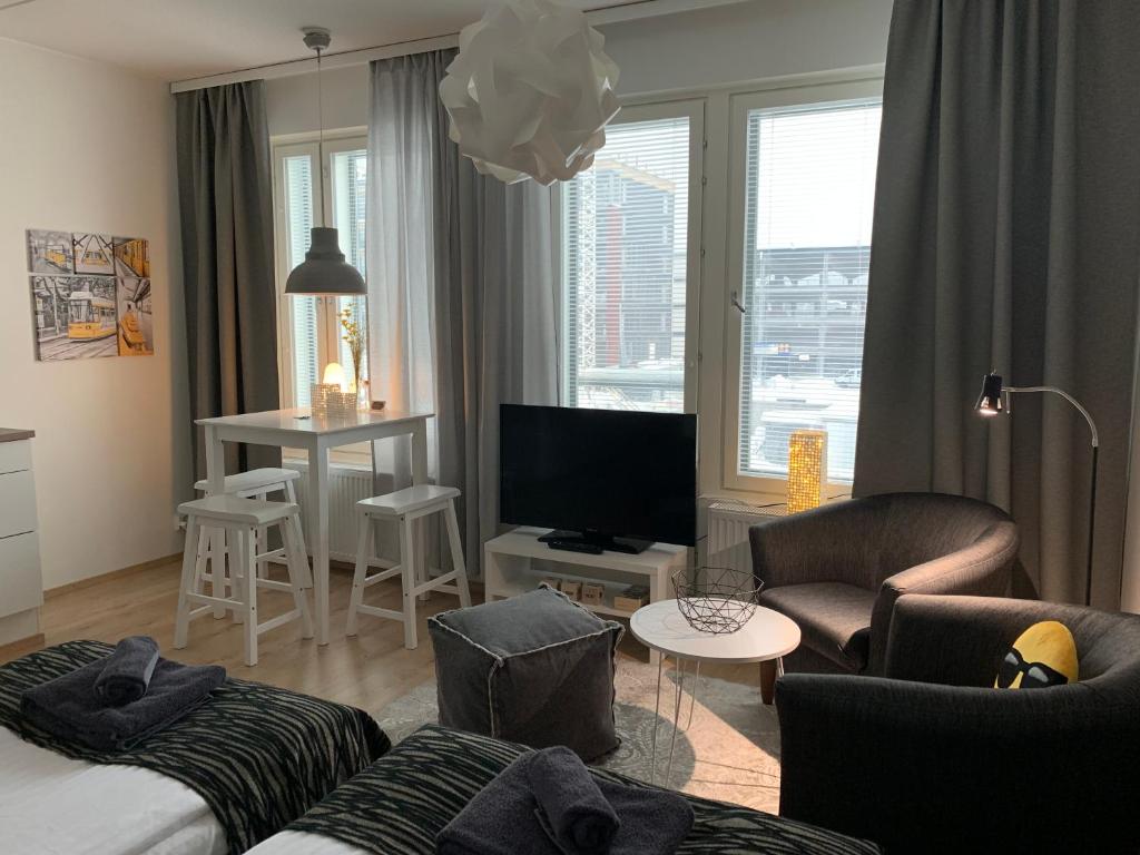 a living room with a couch and a tv at The Harbour Apartments in Jyväskylä
