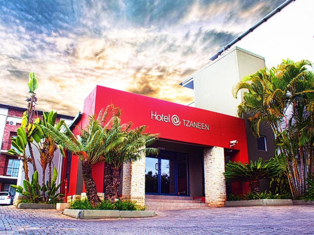 a hotel tamarin with palm trees in front of it at Hotel @ Tzaneen in Tzaneen