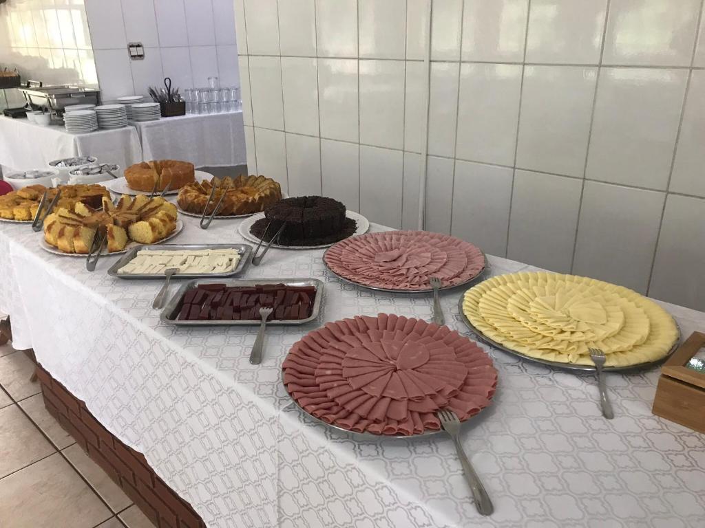 a table with many different types of cakes and pastries at Emburi Hotel in Piratininga