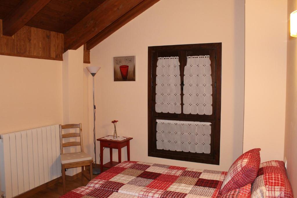 1 dormitorio con 1 cama y una ventana con tazas en Casa Rural Cancias, en Fiscal