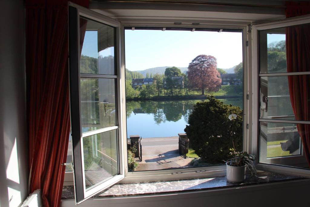 an open window with a view of a lake at Le Pré-Chet in Profondeville
