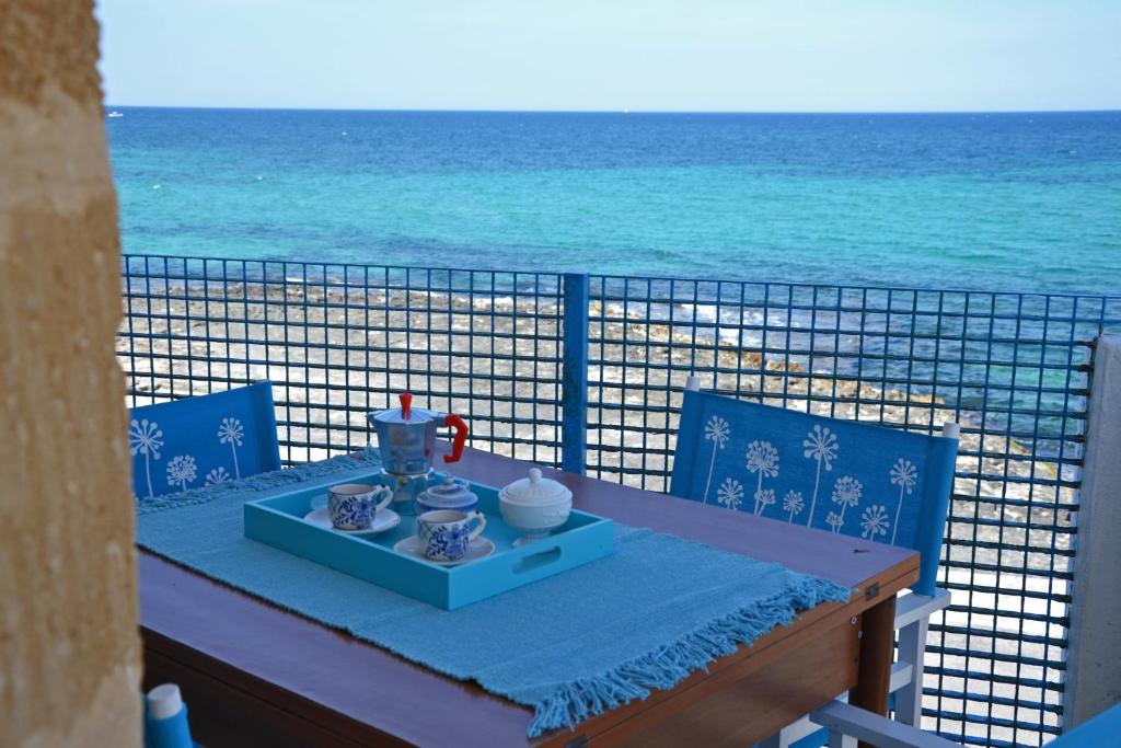 un tavolo su un balcone con vista sull'oceano di Casa Corallo a Villanova