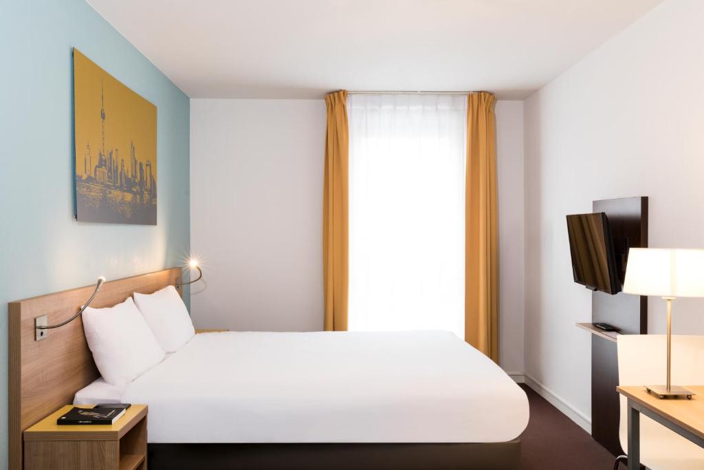 une chambre d'hôtel avec un lit et une fenêtre dans l'établissement Aparthotel Adagio Access Paris Clamart, à Clamart