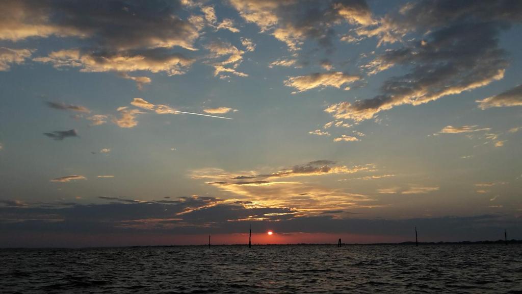 a sunset over the ocean with a cloudy sky at Hotel Belvedere in Venice-Lido