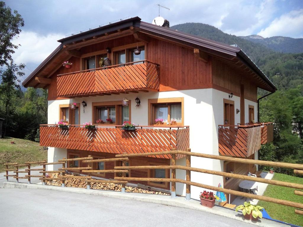 une maison avec une clôture devant elle dans l'établissement B&B Dolomiti, à Calalzo di Cadore