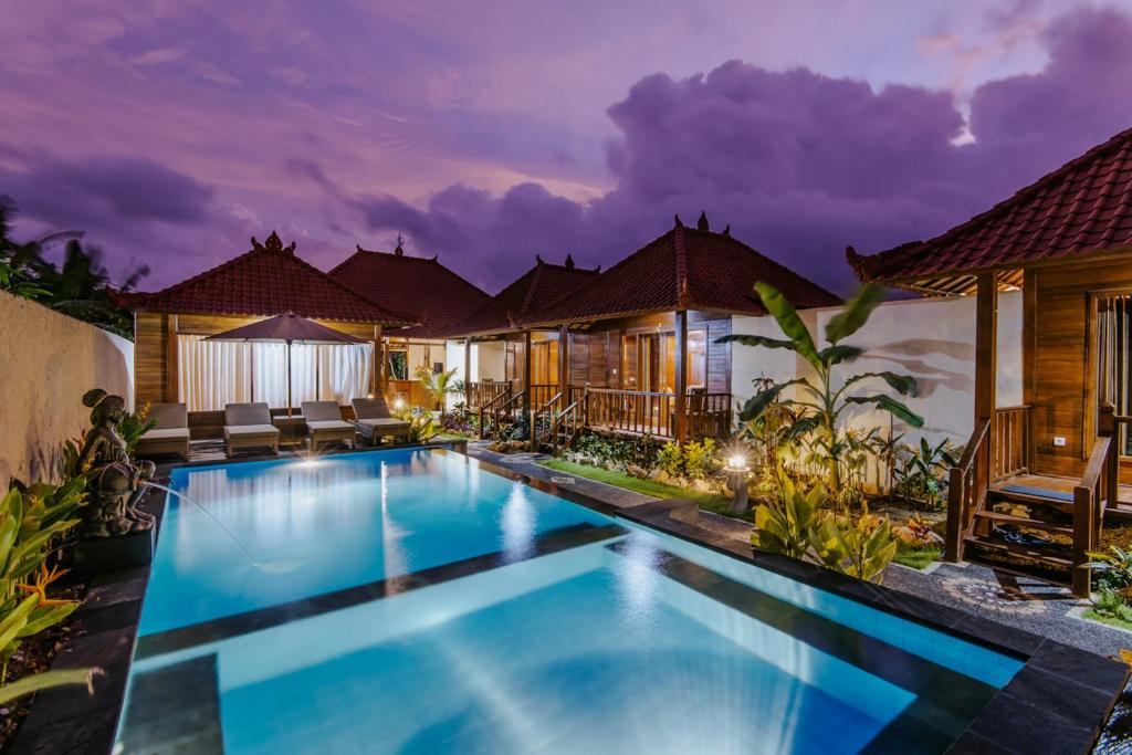 レンボンガン島にあるLembongan Small Heaven Bungalowの夜間のスイミングプール付きのヴィラ