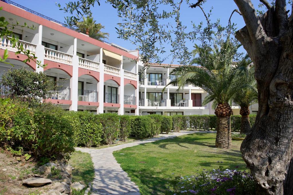 a large pink and white building with a palm tree at Résidence Pierre & Vacances l'Ange Gardien in Villefranche-sur-Mer