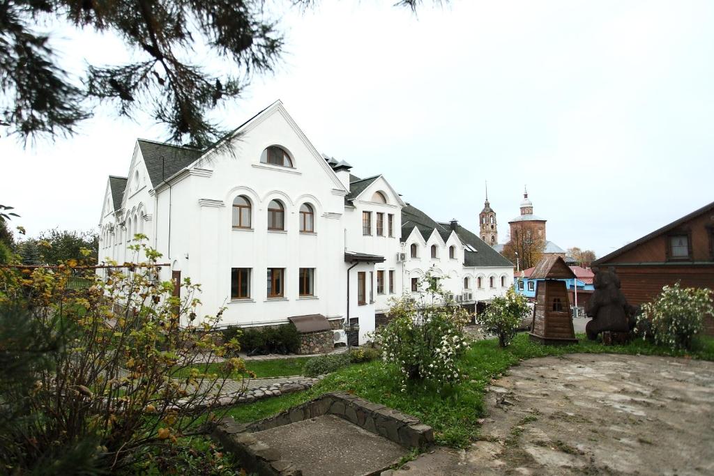 a large white house with a courtyard in front of it at Kremlyovsky Hotel in Suzdal