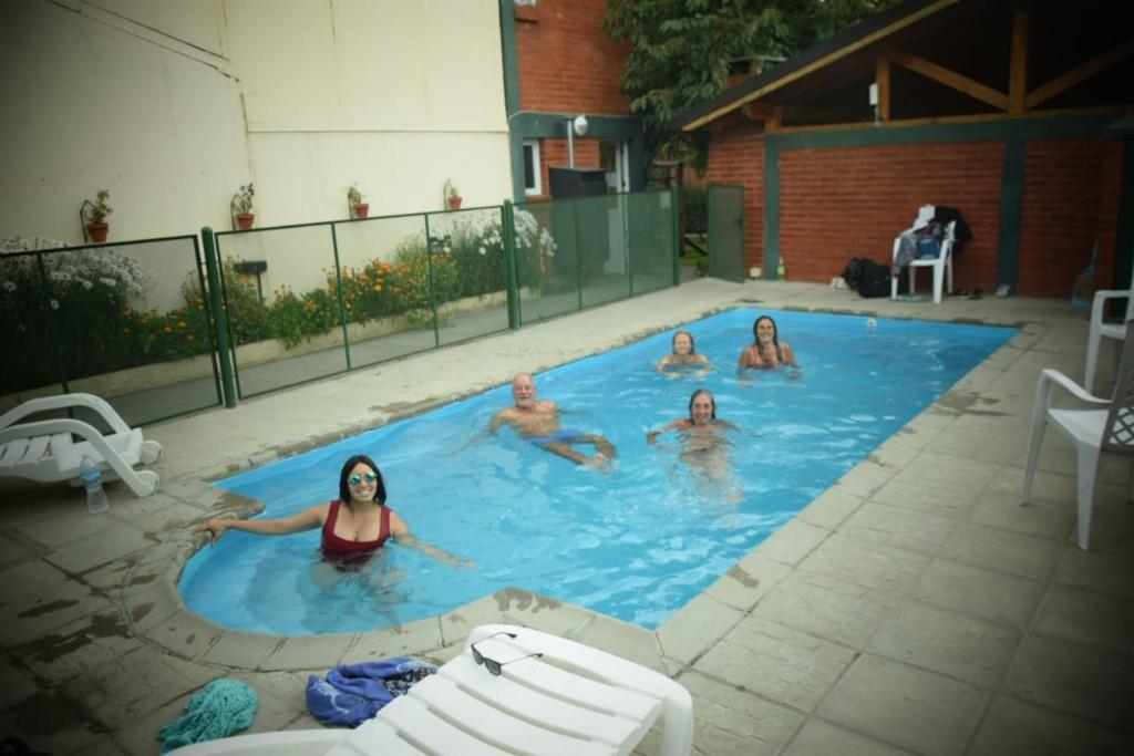 a group of people in a swimming pool at Complejo Turistico Bambu in El Bolsón
