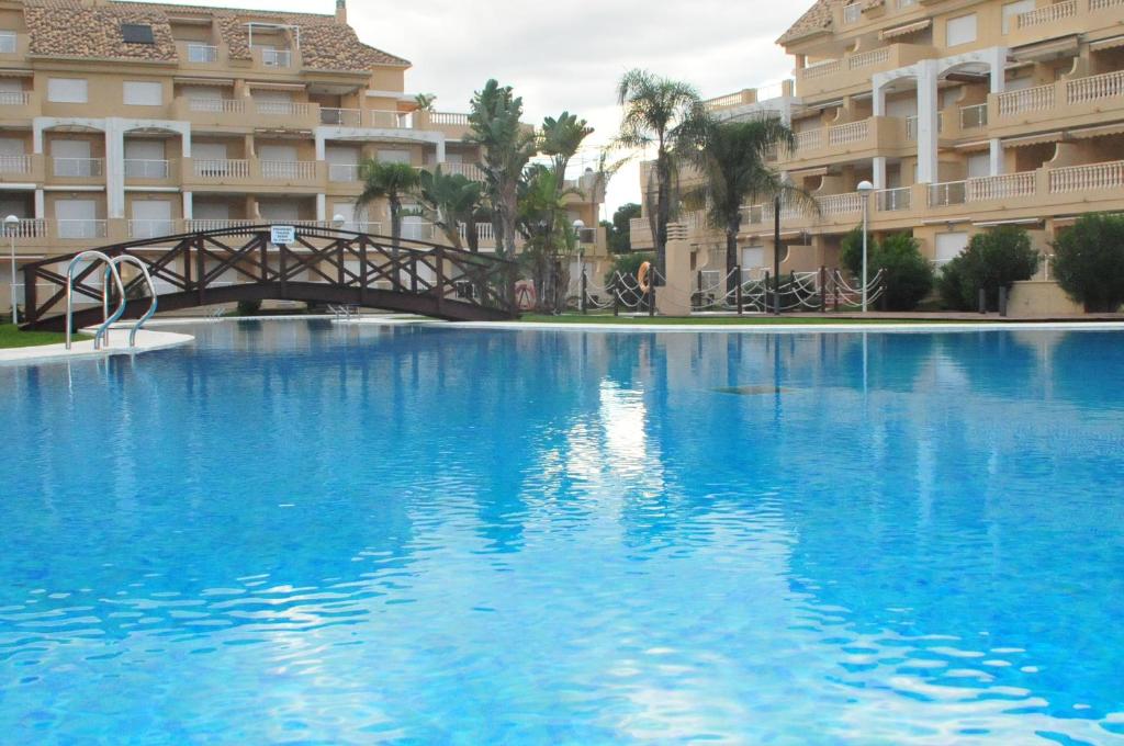 a large blue swimming pool in front of a building at Residencial Tamarindo - Primera línea Gran terraza in Denia