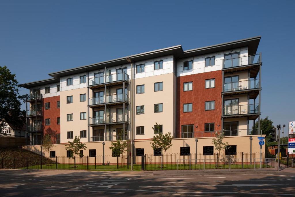 an apartment building on the corner of a street at House of Fisher - Equinox Place in Farnborough