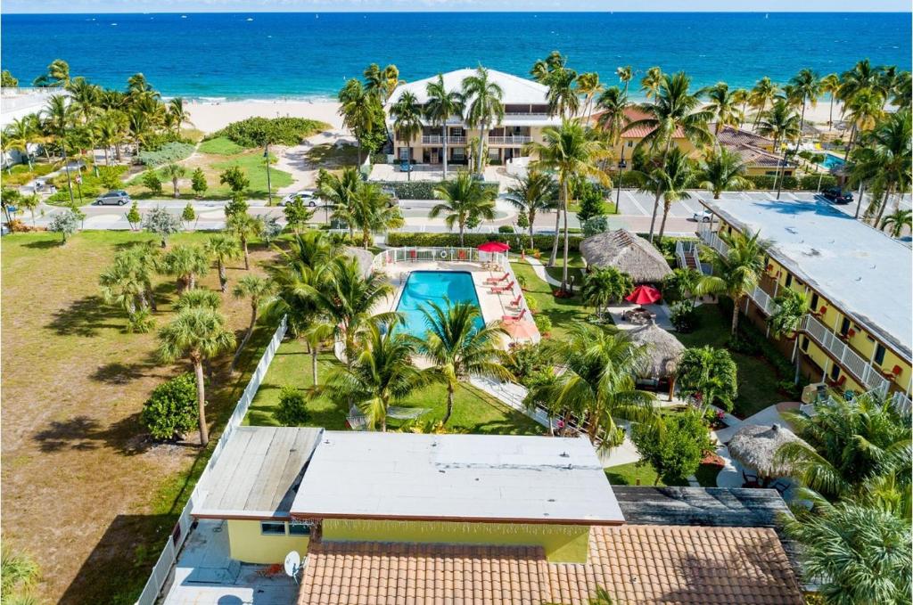 an aerial view of a resort with a pool and the beach at Oceans Beach Resort & Suites in Pompano Beach