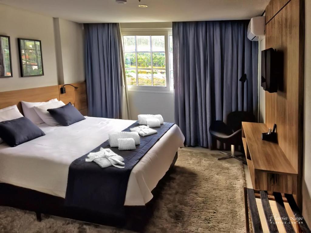 een hotelkamer met een bed met handdoeken erop bij Apartamento Itaipava Granja Brasil in Itaipava