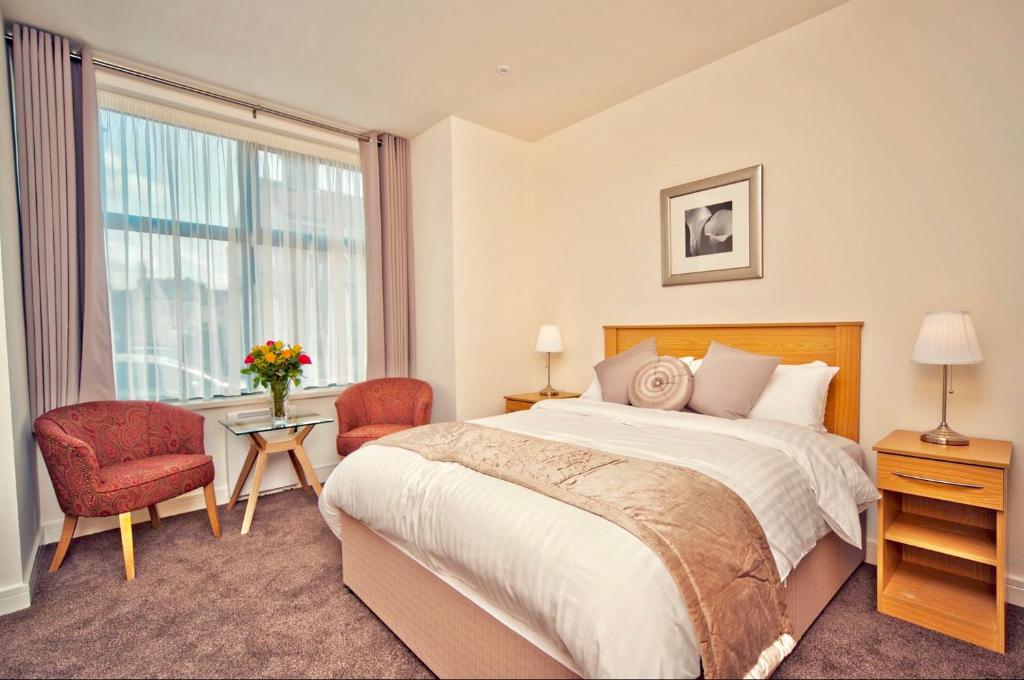 a bedroom with a large bed and a window at The Burlington Hotel in Cleethorpes