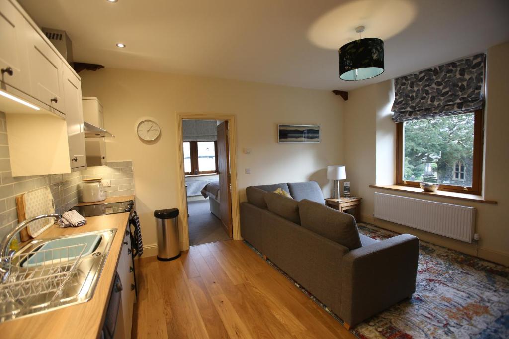 a living room with a couch and a kitchen at Grizedale View in Coniston