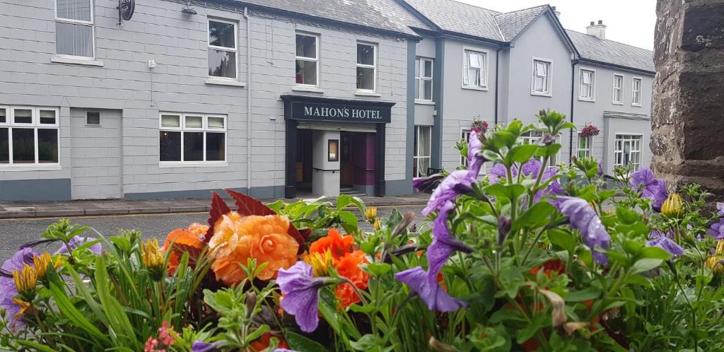 Mahon's Hotel في Irvinestown: حديقة من الزهور أمام المبنى