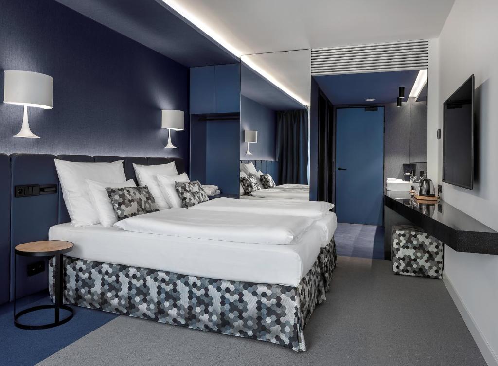 a hotel room with a large bed and a large mirror at Urban Creme in Prague