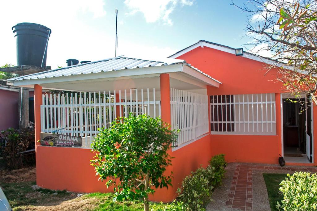 uma pequena casa laranja com uma cerca branca em Ohana Lodging em San Andrés