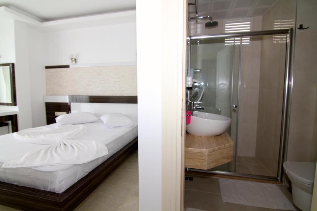 a bathroom with a bed and a shower and a sink at Kas Maki Hotel in Kas