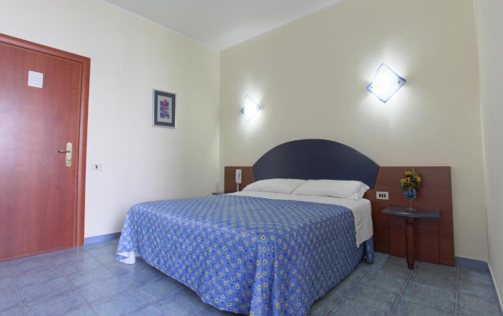 a bedroom with a bed and a dresser at Hotel Lido Degli Angeli in Licata