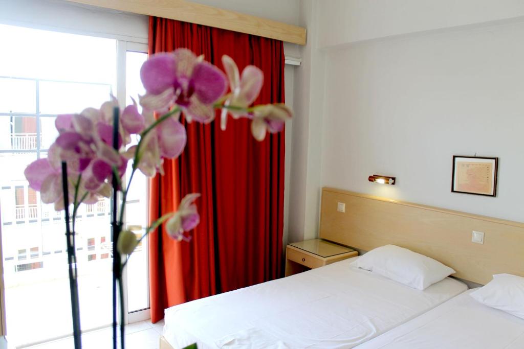 a bed room with a white bedspread and white curtains at Hotel Savoy in Rhodes Town