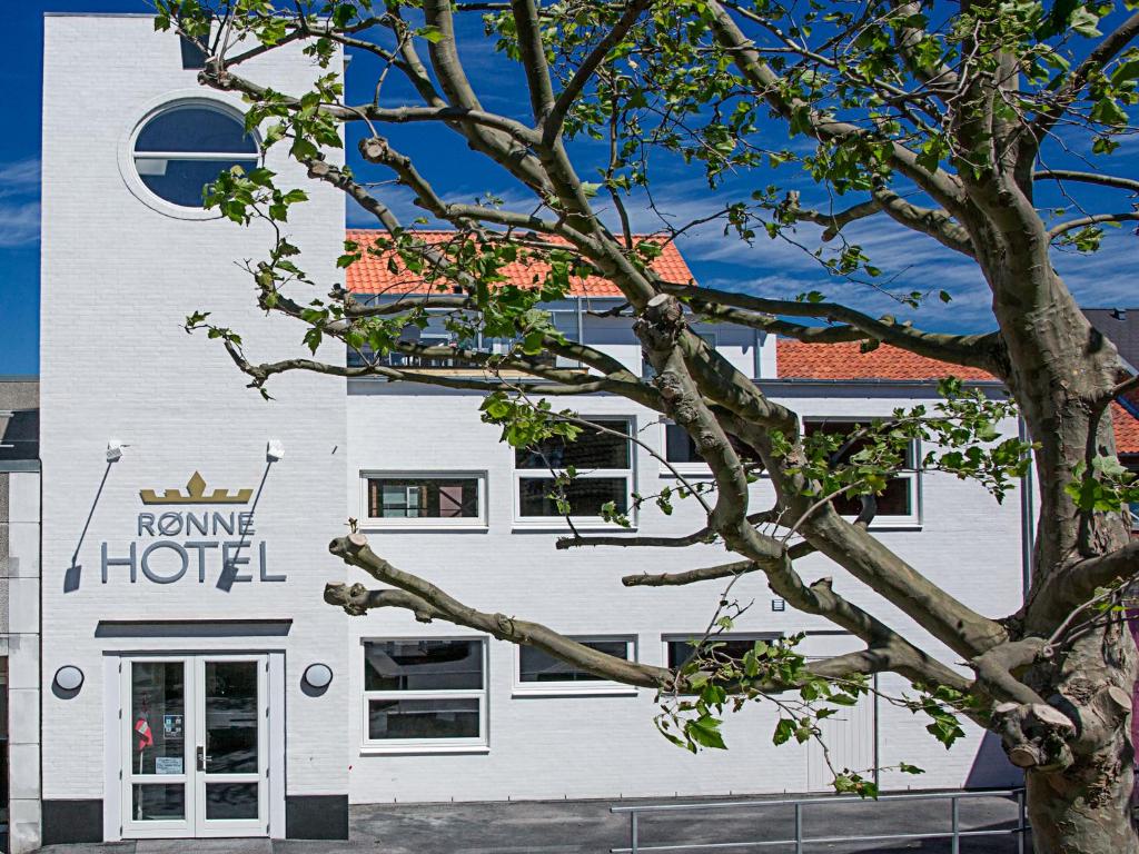 ein weißes Gebäude mit Schild für ein Hotel in der Unterkunft Rønne Hotel in Rønne