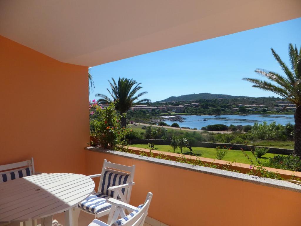 a balcony with a view of a river and palm trees at Residenze Coda Cavallo in San Teodoro