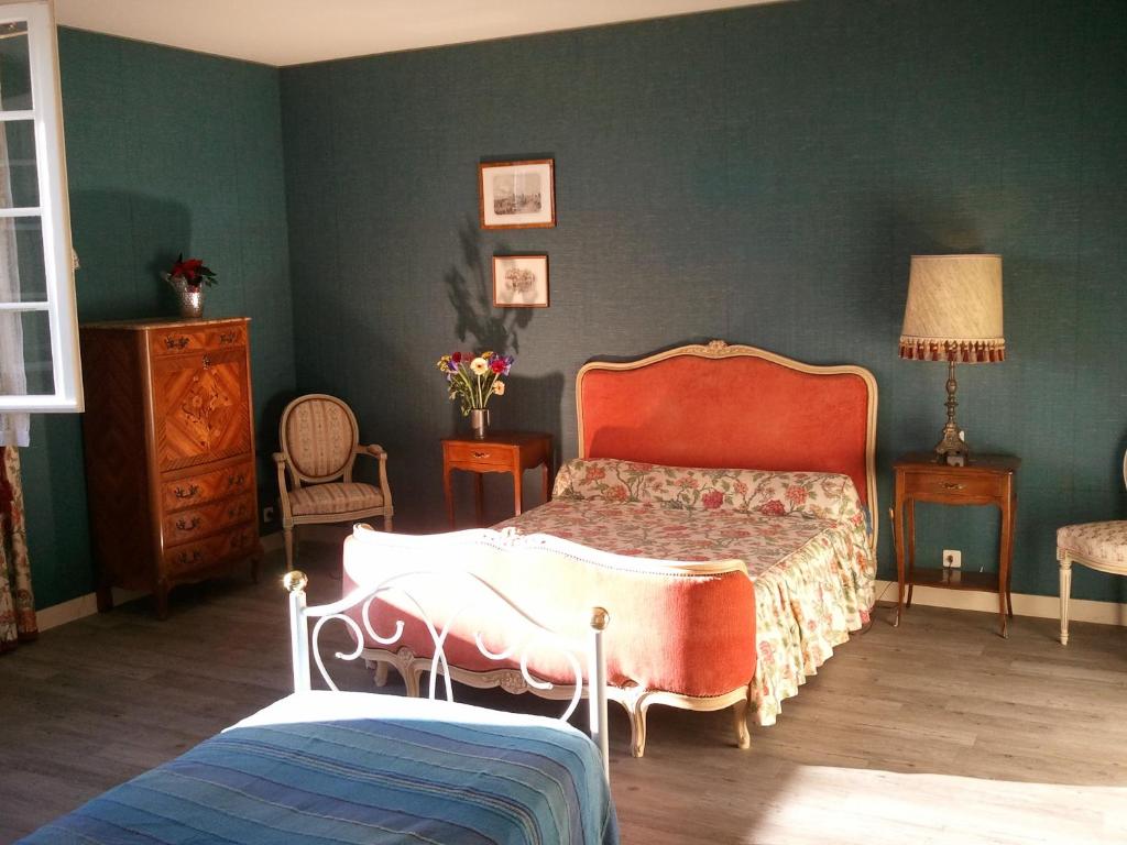 a bedroom with a bed and a green wall at Mas du Trezon in Cholet