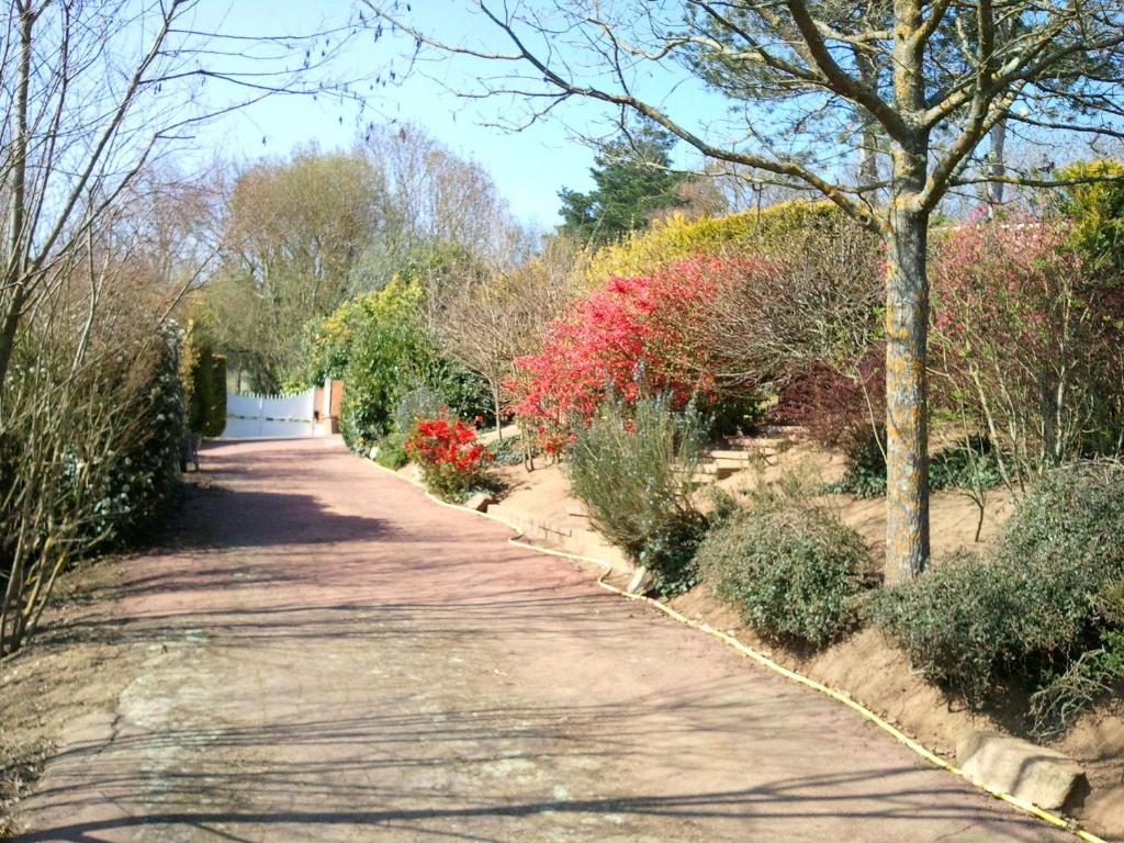 einen Pfad in einem Garten mit Blumen und Bäumen in der Unterkunft Mas du Trezon in Cholet