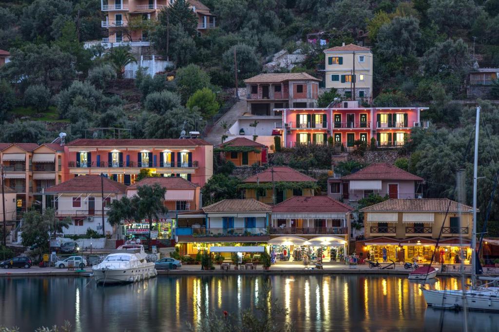 un gruppo di edifici su una collina vicino a un corpo idrico di Galini Studios a Sivota