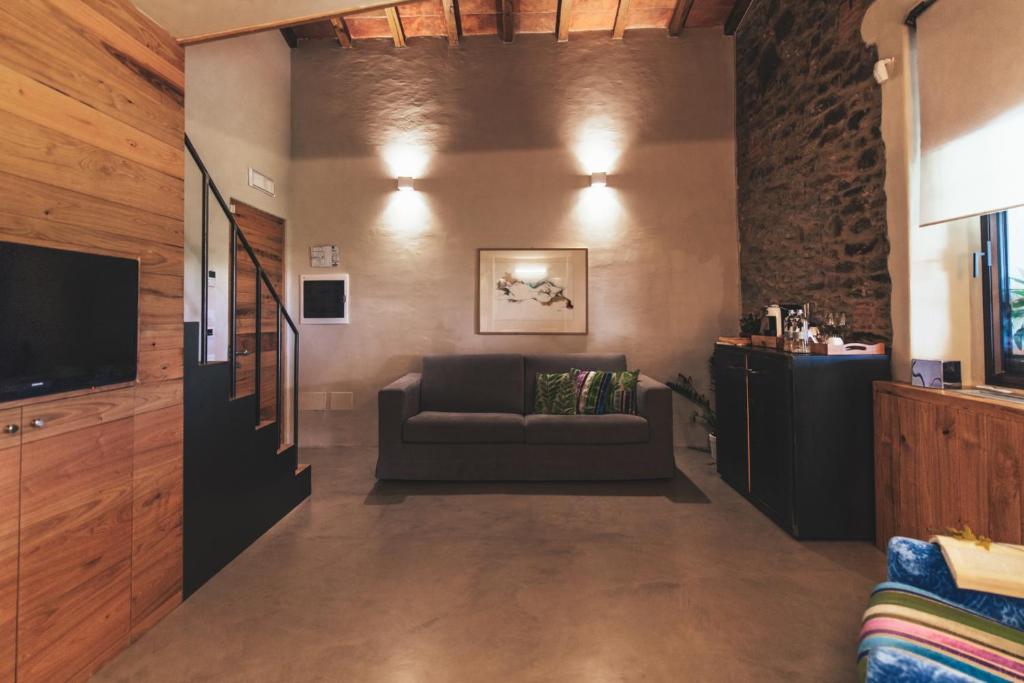 a living room with a couch and a television at Torre di Baratti Bio Resort in Populonia