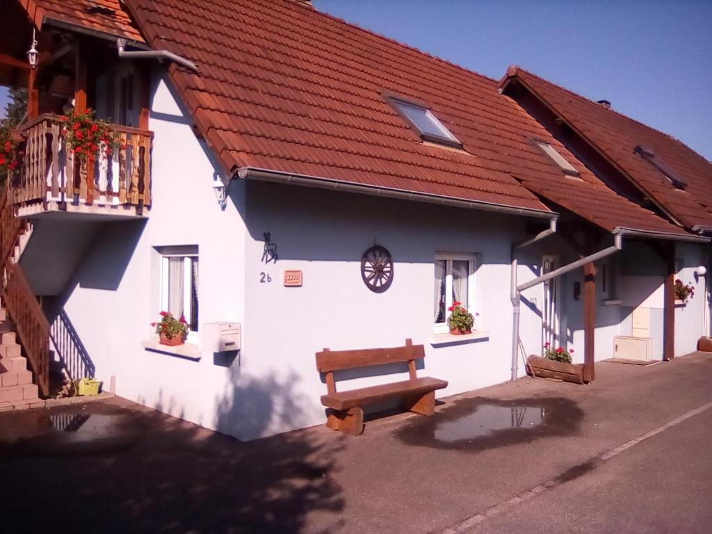 a white building with a bench in front of it at Les gîtes du lindenberg in Dambach