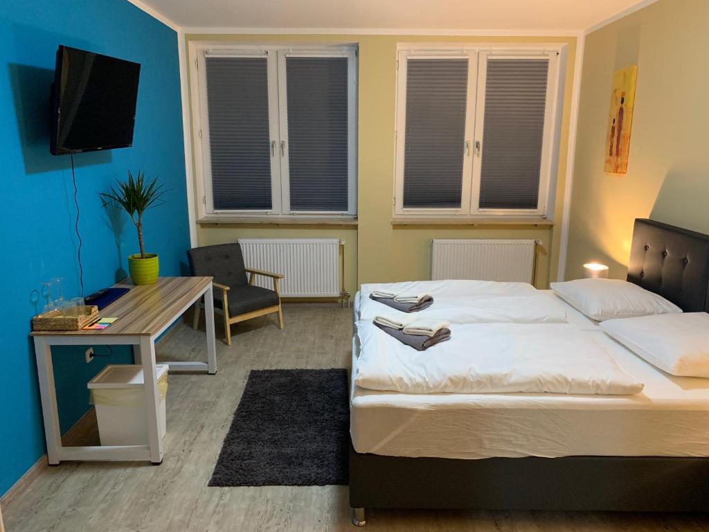a hotel room with two beds and a television at White Pearl Hostel 1 in Nuremberg