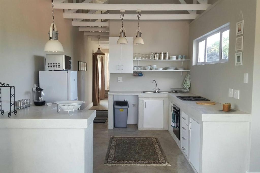 una cucina con banconi bianchi ed elettrodomestici bianchi di Nova Skye a Johannesburg