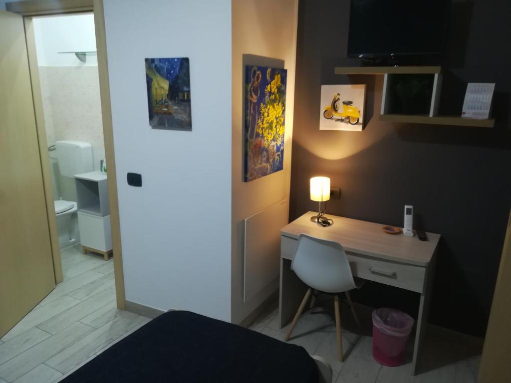 a bedroom with a desk and a bed with a lamp at Piazza Castello in Santo Stefano Quisquina