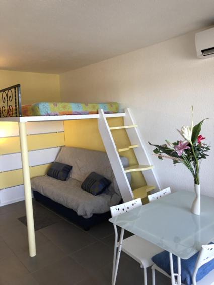- une chambre avec des lits superposés, un bureau et une table dans l'établissement Studio 21m2 Port-Camargues, le Grau du Roi, au Grau-du-Roi