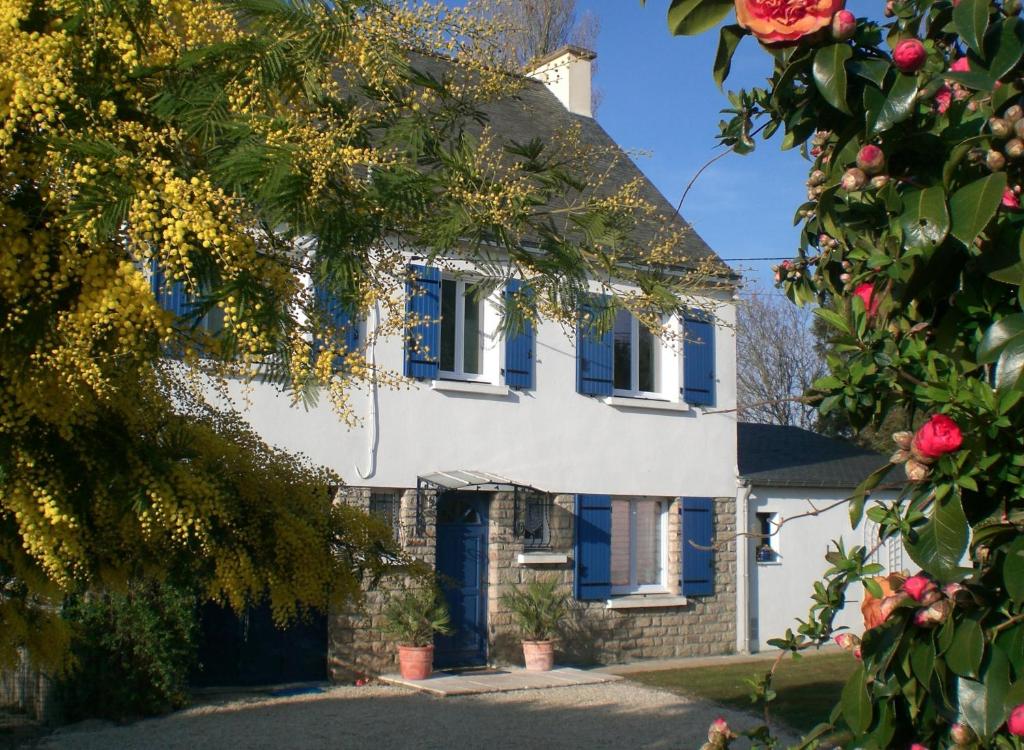 Casa blanca con persianas azules y flores en Chambre D'Hôtes Mont D'Hermine, en Arradon