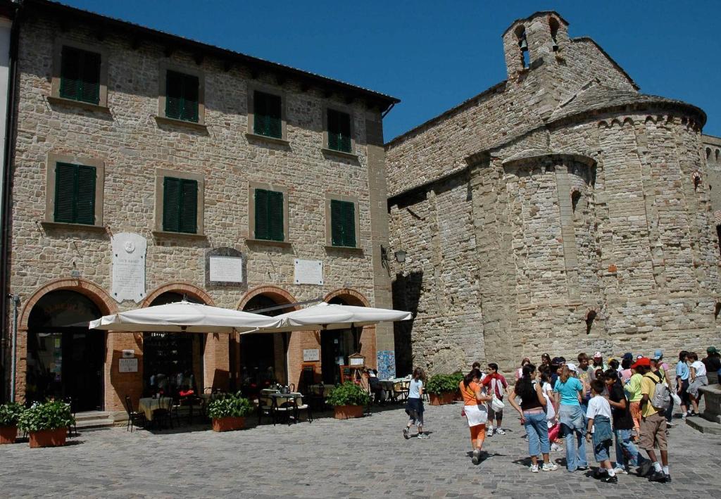 a group of people walking in front of a building at San Leo Albergo Diffuso in San Leo
