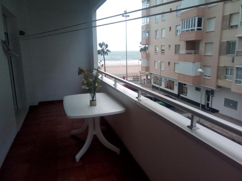 Cette chambre dispose d'une table et d'une fenêtre avec vue sur la plage. dans l'établissement Azul Maritimo, à Cadix