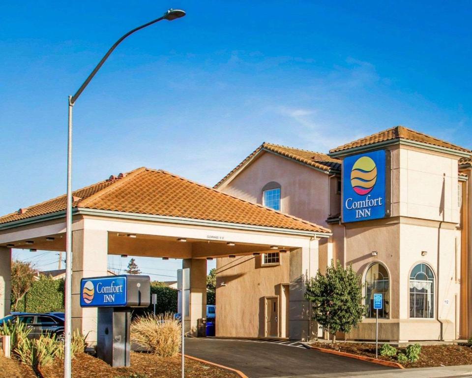 un edificio con un cartel de concesionario de automóviles en Comfort Inn Watsonville en Watsonville