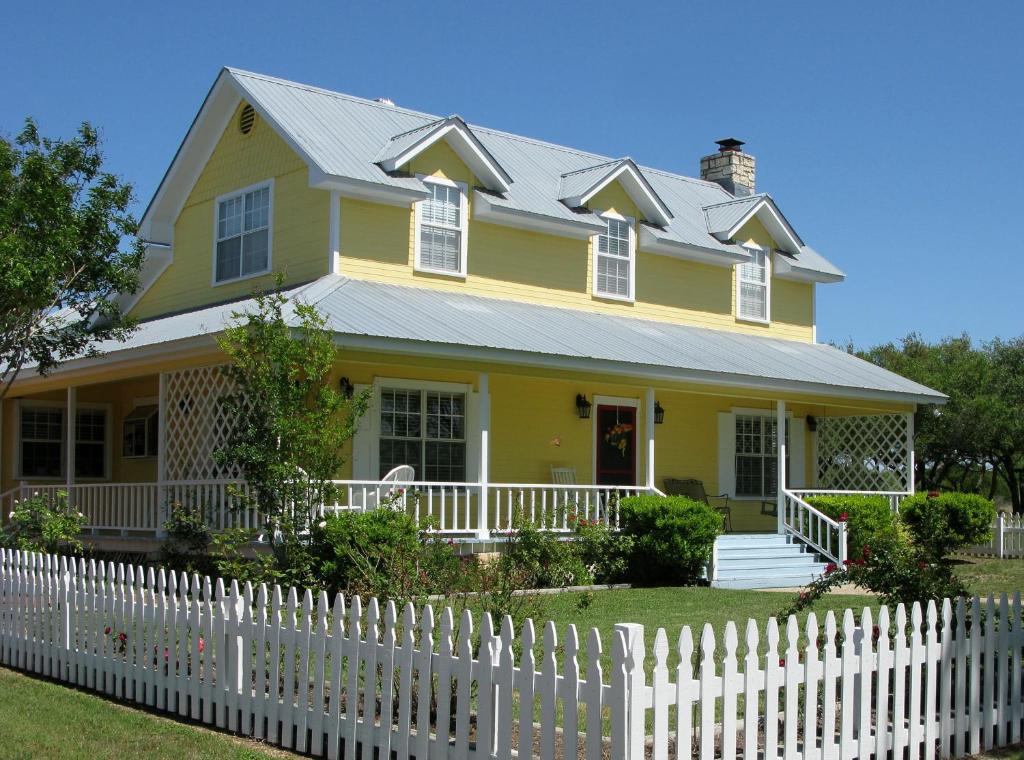 a yellow house with a white picket fence at Yellow House B&B in Salado