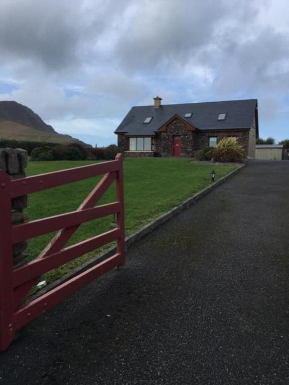 a red fence in front of a house at Gort a Phump in Ballydavid