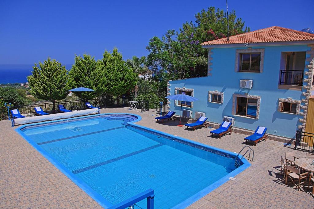 a villa with a swimming pool in front of a house at Marilena Sunset Villa 2 in Ayia Marina